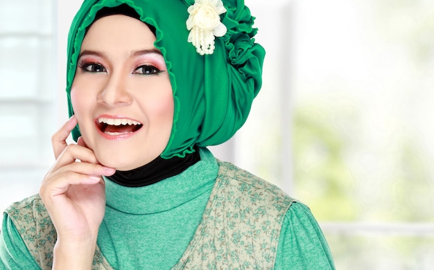 Feliz muçulmana linda jovem com traje verde usando hijab