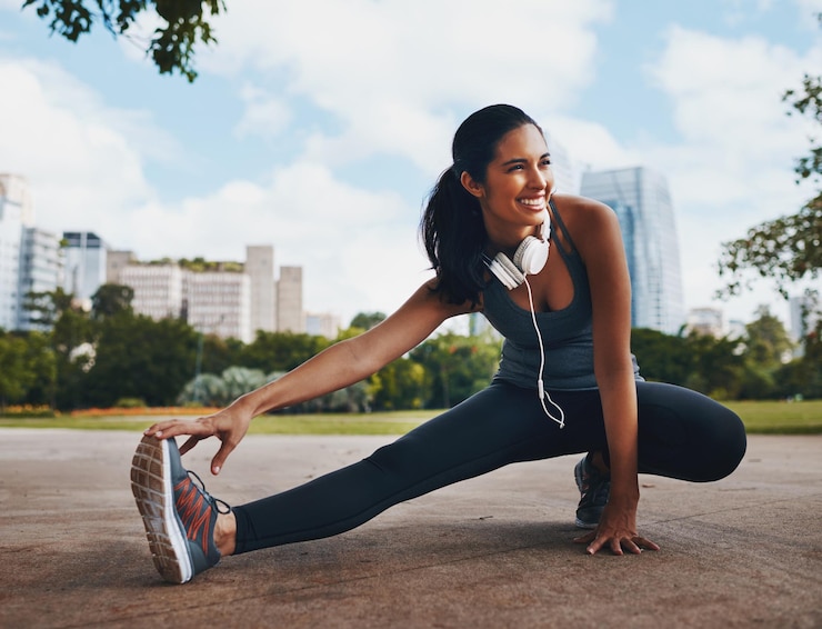 Foto feliz mujer acondicionamiento físico y estiramiento de las piernas en el parque en la ciudad para un cuerpo saludable flexible y ejercicio para el bienestar deportes de inicio y corredor calentar el músculo para prepararse para el entrenamiento de entrenamiento o perder peso