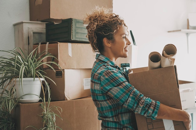 Feliz mujer adulta reubicando casa levantando caja de cartón con cosas de vida Emoción de nuevos comienzos Viviendo sola Gente femenina moderna en mudarse a casa apartamento ocio actividad interior sola Alegre