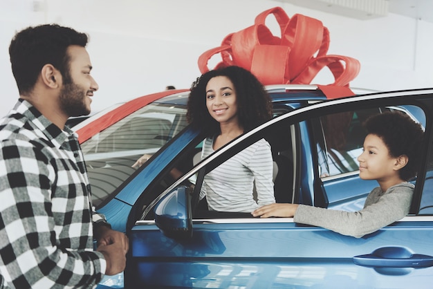 Feliz mujer afro orgullosa tiene nuevo coche de lujo