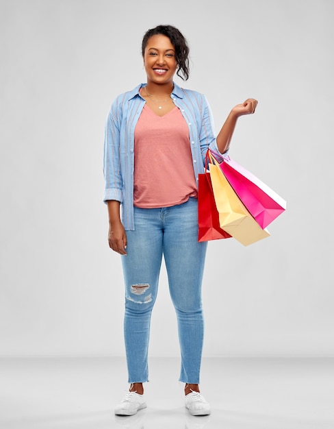 feliz mujer afroamericana con bolsas de compras