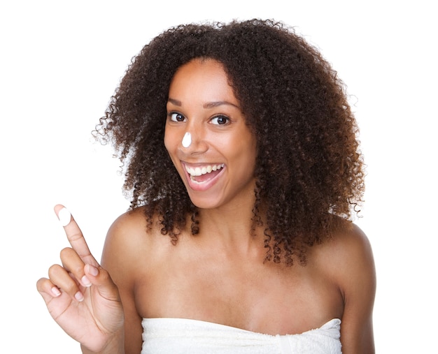 Feliz mujer afroamericana con crema en el dedo y la nariz