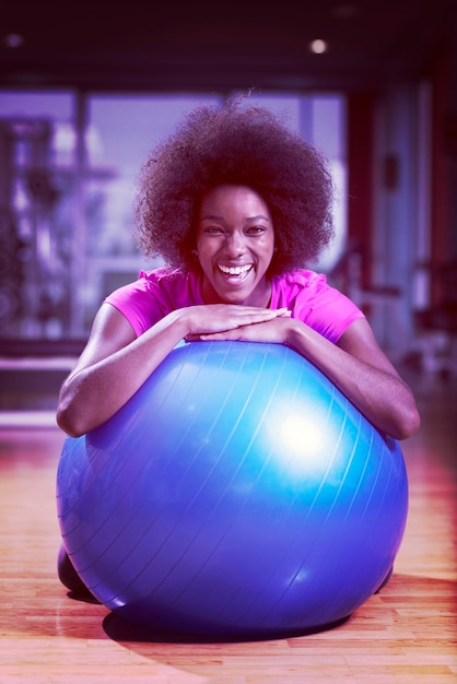 feliz mujer afroamericana con un peinado afro rizado en un gimnasio relajándose después del entrenamiento de pilates