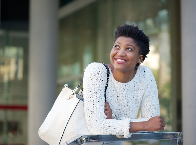 Feliz mujer afroamericana sonriendo en la ciudad