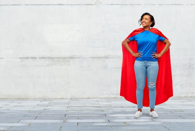 feliz mujer afroamericana en superhéroe capa roja