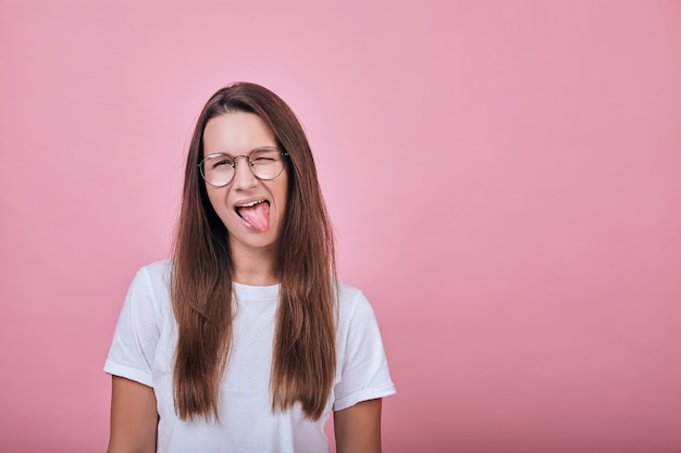 Feliz mujer alegre con su lengua sobresaliendo hacia un lado y cubierta con un ojo