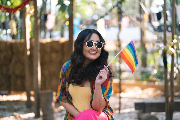 Foto feliz mujer asiática apoya el desfile del orgullo lgbt con rainbow of lgbtq o lgbtqia