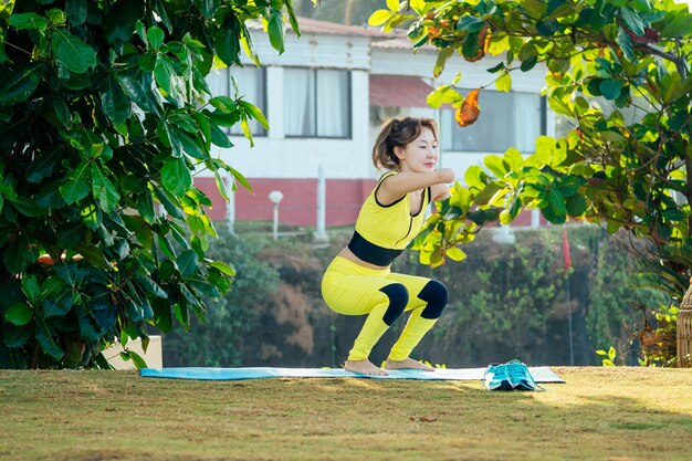 Feliz mujer asiática sin brazos calentándose antes de nadar en la playa tropical