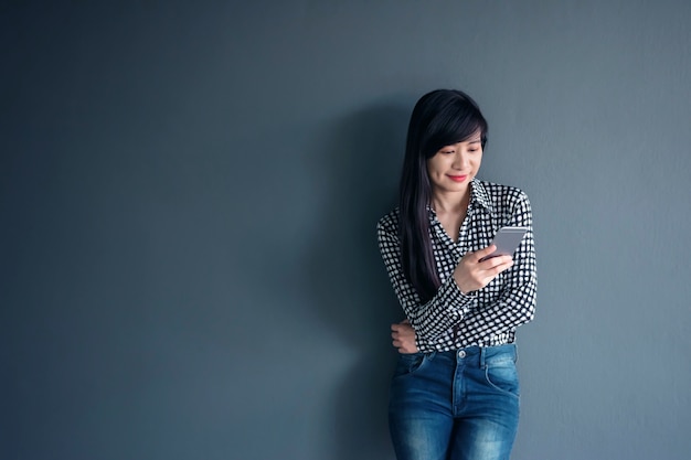 Feliz mujer asiática sonrisa y uso de teléfono inteligente móvil