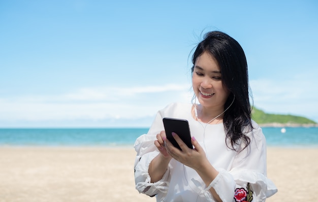 Feliz mujer asiática usando teléfono inteligente