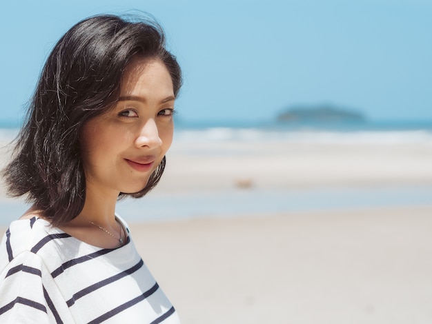 Feliz mujer asiática en vacaciones de playa de verano