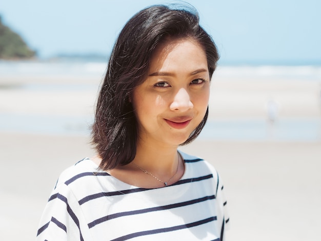 Feliz mujer asiática en vacaciones de verano en la playa.