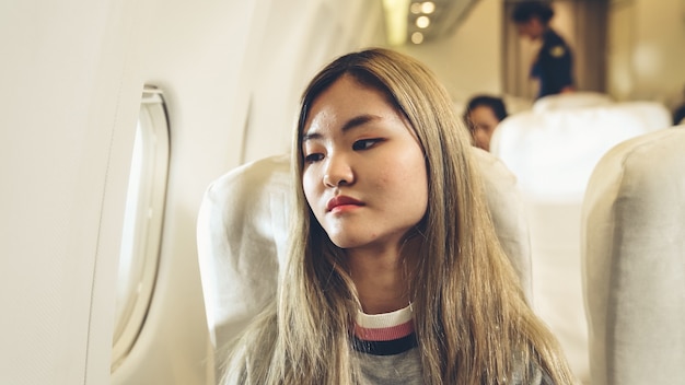 Feliz mujer asiática viaja en avión para turismo de vacaciones.