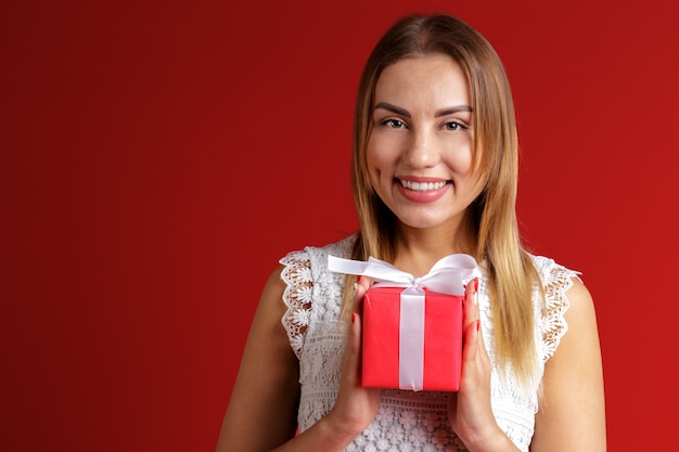 Feliz mujer bastante joven con caja de regalo