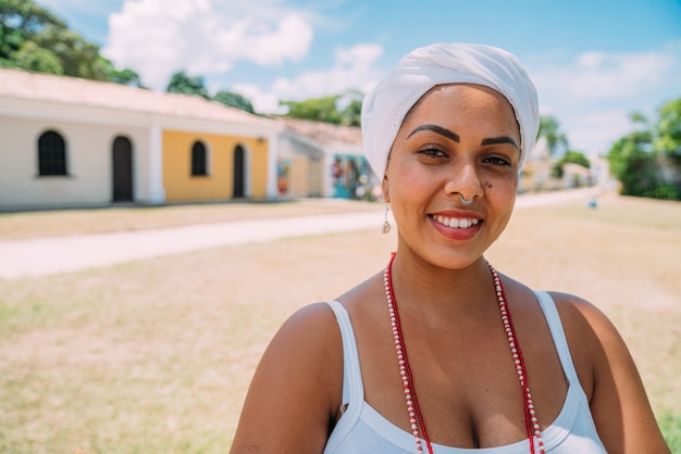 Feliz mujer brasileña vestida con traje tradicional bahiano bailando en el centro histórico de Porto Seguro