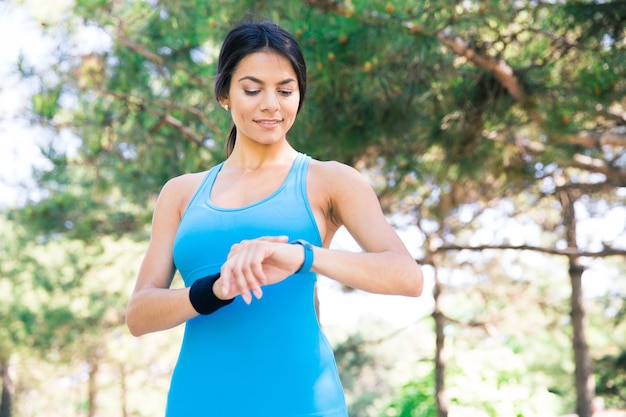 Feliz mujer deportiva con reloj inteligente