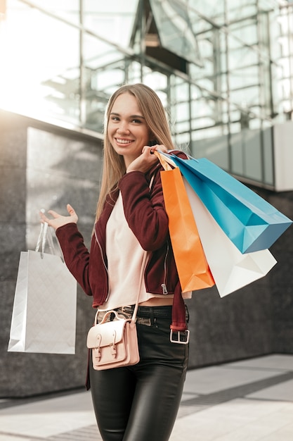 Feliz mujer elegante con bolsas de colores