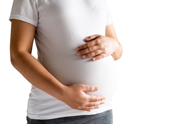 Feliz mujer embarazada con bebé en vientre embarazado en blanco.