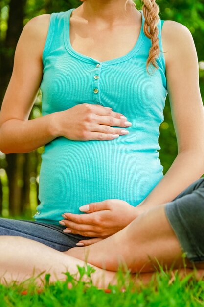 Feliz mujer embarazada con un chico en un parque de la naturaleza