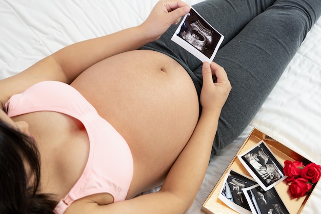 Foto feliz mujer embarazada y esperando bebé.