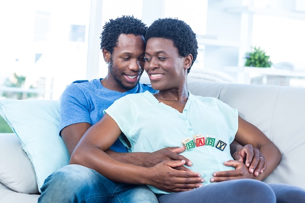 Feliz mujer embarazada con marido tocando su vientre