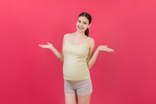 feliz mujer embarazada sorprendida posando aislada sobre el fondo de color espacio de copia