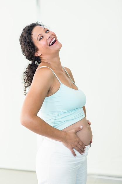 Feliz mujer embarazada tocando su vientre