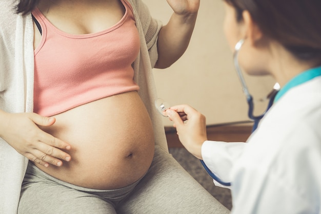 Feliz mujer embarazada visita al médico ginecólogo en el hospital o clínica para consultor de embarazo.