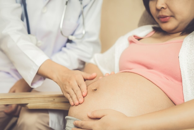 Feliz mujer embarazada visita al médico ginecólogo en el hospital o clínica para consultor de embarazo.