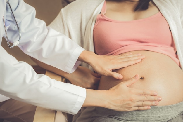 Feliz mujer embarazada visita al médico ginecólogo en el hospital o clínica para consultor de embarazo.