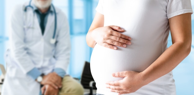 Feliz mujer embarazada visita al médico ginecólogo en el hospital o clínica para consultor de embarazo.