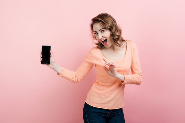 Feliz mujer emocionada con un teléfono inteligente en la mano