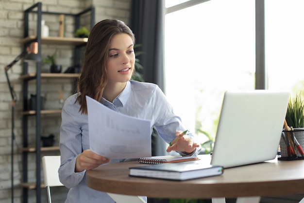 Feliz mujer emprendedora sentarse en el escritorio leyendo buenas noticias en correspondencia postal.