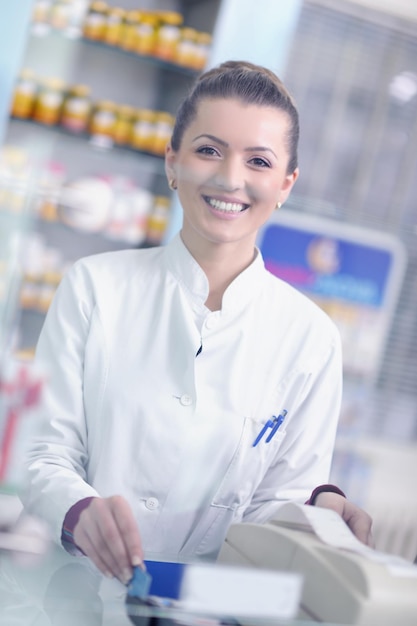 Foto feliz mujer farmacéutica alegre farmacéutica de pie en la farmacia farmacia