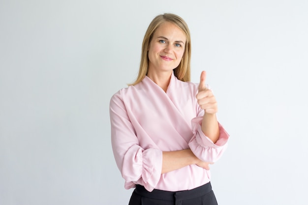 feliz mujer gerente caucásica vistiendo blusa rosa mostrando pulgar arriba