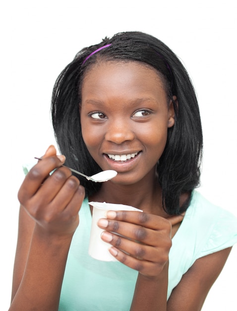 Feliz mujer joven comiendo un yogurt