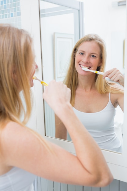 Feliz mujer limpiándose los dientes