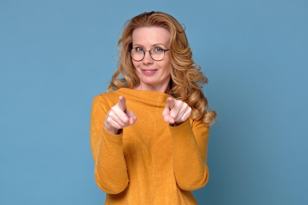 Feliz mujer madura con gafas apuntándote te elijo a ti