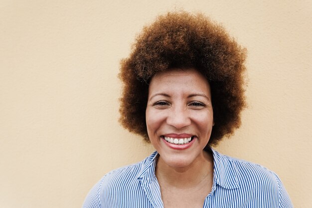 Feliz mujer mayor africana sonriendo a la cámara al aire libre en la ciudad - Centrarse en la cara