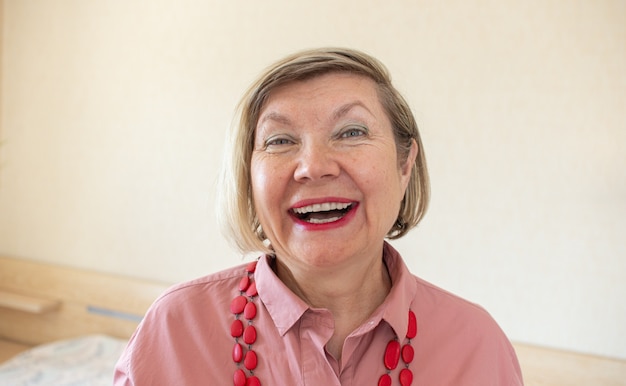 Feliz mujer mayor de moda mujer mayor de cabello gris, madura de mediana edad, mujer mayor sonriente con gafas y abalorios en casa, mujer jubilada senior solitaria positiva