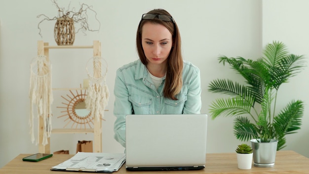 Feliz mujer morena trabajando en un portátil en casa