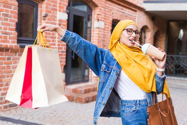 Feliz mujer musulmana árabe con bolsas de la compra.