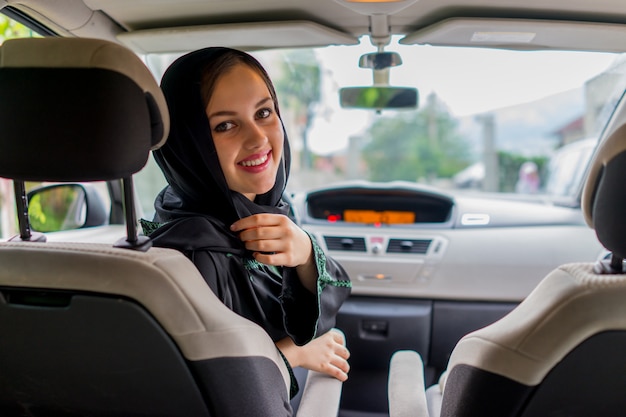 Foto feliz mujer musulmana y su hijo conduciendo en un coche