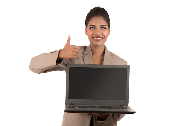 Feliz mujer de negocios emocionada sosteniendo el portátil y mostrando los pulgares para arriba aislado