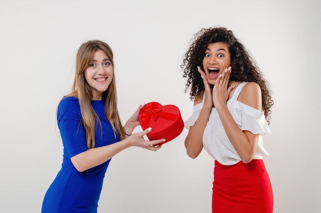 Feliz mujer negra que recibe el cuadro presente de San Valentín en forma de corazón de novia aislada