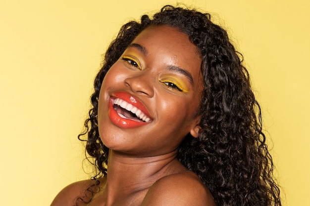 Feliz mujer negra con sombra de ojos amarilla