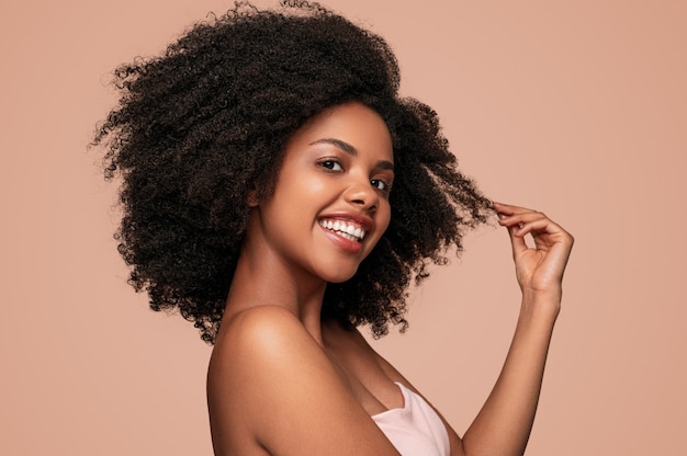 Feliz mujer negra tocando el cabello limpio