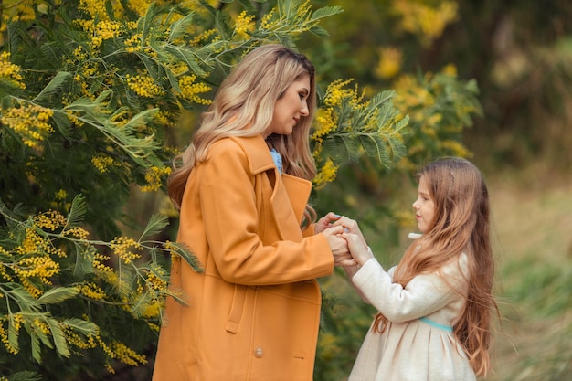 Feliz mujer y niño en el floreciente jardín de primavera Concepto de vacaciones del Día de la Madre