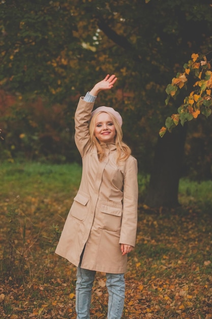 Feliz mujer de otoño en el fondo de la naturaleza de otoño