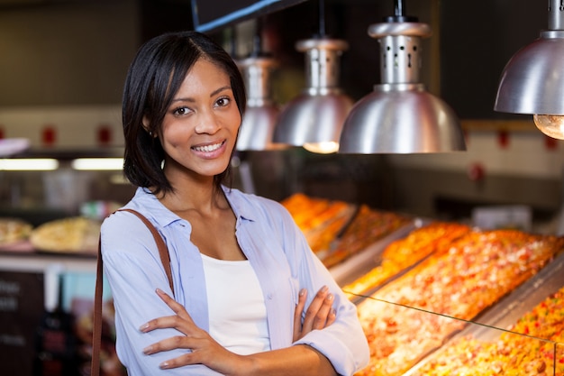 Feliz mujer de pie en el mostrador de comida